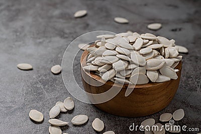 Pumpkin seeds in wooden bowl on the cement floor Stock Photo