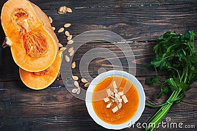 Pumpkin soup in a bowl with fresh pumpkins, parsley herbs Stock Photo