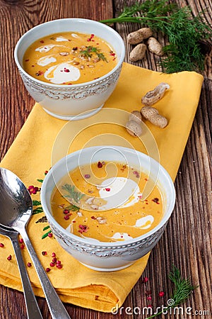 Pumpkin soup with peanuts on a wooden table Stock Photo