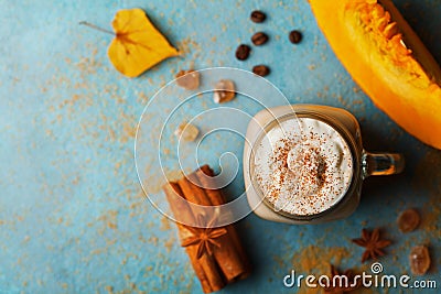 Pumpkin spiced latte or coffee in cup decorated cinnamon on turquoise vintage table top view. Autumn, fall or winter hot drink. Stock Photo