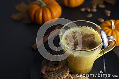 Pumpkin spiced latte macchiato on a dark wooden background autumn drink beverage golden milk Stock Photo