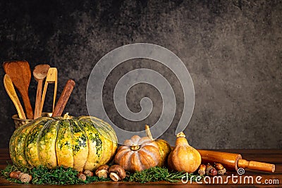 Pumpkins, butternut squash, mushrooms with cooking ustencils and rolling pin on a table over a vintage background with copy space Stock Photo