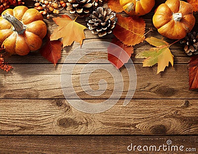 Pumpkins, pine cones, and fall leaves adorn a rustic wood surface, evoking a cozy autumn ambiance Stock Photo