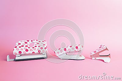 Puncher, stapler and staple remover, with pink dots on a pink background. Office and school supplies concept. Copy-space Stock Photo