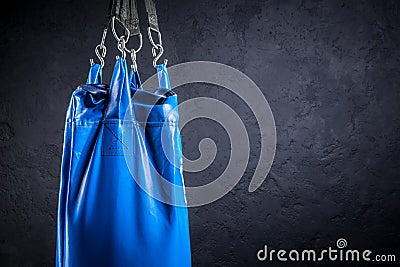 Punching bag blue against a plastered wall Stock Photo