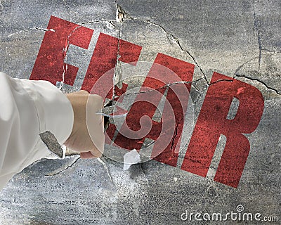 Punching, break concrete wall with word fear on it and small pie Stock Photo