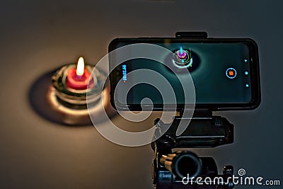 Pune,Maharashtra,India-May 31st,2020:Recording of video of diya on cell phone mounted on tripod. Stock Photo