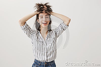 Punks not dead. Portrait of funny attractive woman with sense of humour lifting up hair with hands, looking like rock n Stock Photo