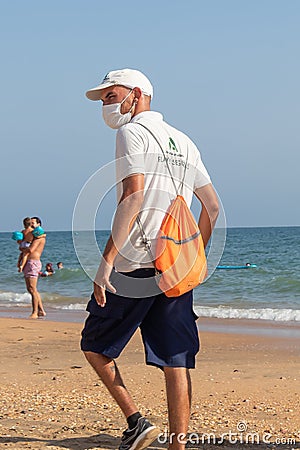 Punta Umbria, Huelva, Spain - August 7, 2020: Beach safety guard of Junta de Andalucia is controlling the social distancing and Editorial Stock Photo