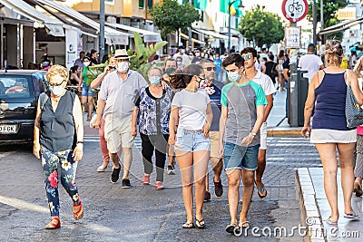 Punta Umbria, Huelva, Spain - July 3, 2020: People walking by calle Ancha street wearing protective mask due to covid-19 Editorial Stock Photo