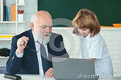 Pupil learning. Boy elementary school. Old and Young. Professor and pupil in classroom. Child at school lesson with Stock Photo