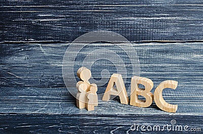 The pupil and pupils stand at the big letters ABC of the English alphabet. Parent and children. The concept of education Stock Photo