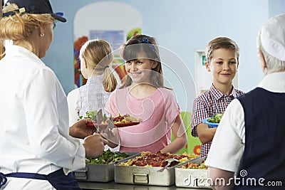 Pupils Being Served With Healthy Lunch In School Canteen Stock Photo