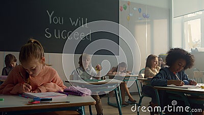 Pupils learning in classroom. Female and male students sitting at desks Stock Photo