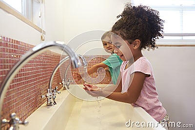 Pupils At Montessori School Washing Hands In Washroom Stock Photo