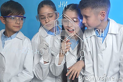 Pupils studying chemistry formula on glass board Stock Photo