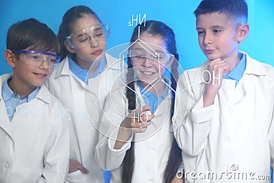 Pupils studying chemistry formula on glass board Stock Photo