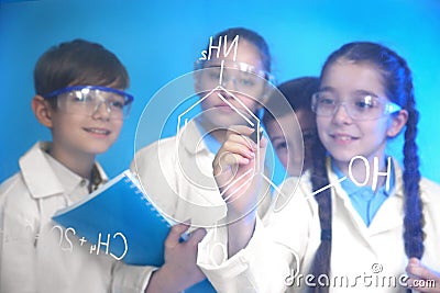 Pupils writing chemistry formula on glass board Stock Photo