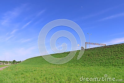 Pure blue sky, bright green lawn and road on hill Stock Photo