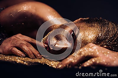 Pure gold. Vogue and glamour concept. Golden skin. Sexy girl face makeup body art metallized color. Spa wellness Stock Photo