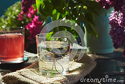 Purified aesthetic outdoor table with pure glass of water, compote and flowers. Aesthetic breakfast in the garden, water Stock Photo