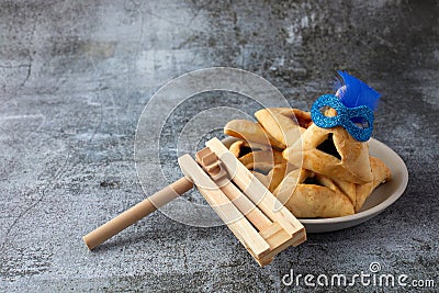 Purim celebration concept with hamantashen cookies, Purim mask and toy noisemaker on grey background Stock Photo