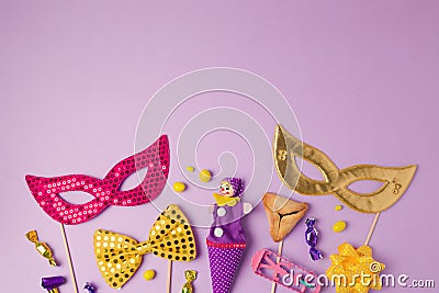 Purim holiday concept with carnival mask and party supplies on purple background. Top view from above Stock Photo