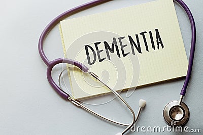 On a purple background a stethoscope with yellow list with text DEMENTIA Stock Photo