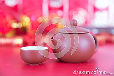 Purple clay milk pot and tea bowl on red background. The Chinese characters in the picture mean `happiness` Stock Photo