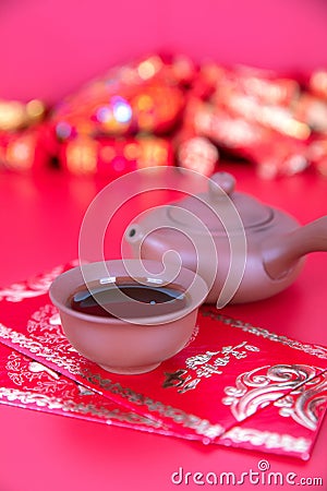 Purple Clay Tea Set and New Year Red Packets on Red Background.The Chinese characters in the picture mean `happiness` Stock Photo