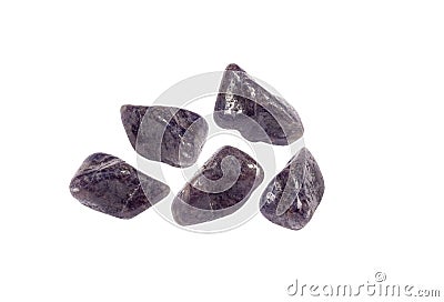 Purple color tumbled Iolite or Cordierite gemstones, isolated on white background, lot of copy space. Stock Photo