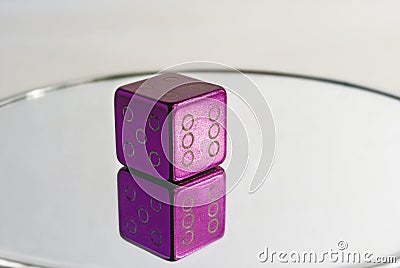 Purple dice on the mirror. The cap on the nipple Stock Photo