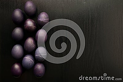 Purple easter eggs, on a black wooden background. The concept of Stock Photo