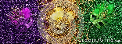 Purple, Gold, and Green Mardi Gras beads and masks Stock Photo