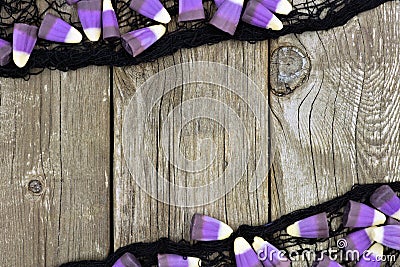 Purple Halloween candy corn and black cloth frame against wood Stock Photo