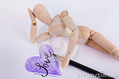 Purple hand drawn heart word love inside jointed manikin doll daydreaming Stock Photo