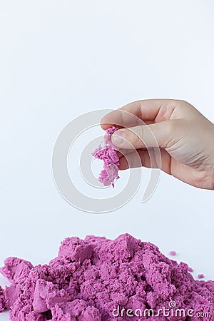 Purple kinetic sand in hand isolated on a white background Stock Photo
