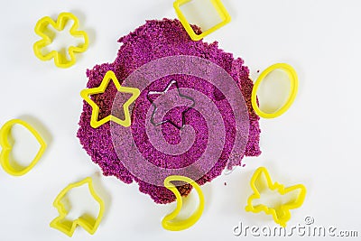 Purple kinetic sand, plastic molds for sand. Top view. White background, close-up view Stock Photo