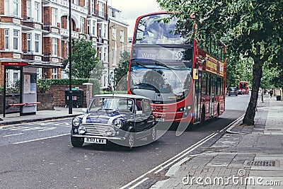 The purple mini cooper and the Routemaster on Abbey Road in the City of Westminster, London Editorial Stock Photo