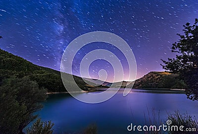 Purple night sky stars lake landscape with milky way on mountain Stock Photo