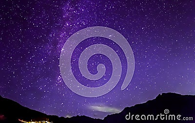 Purple night sky stars. Milky way across mountains Stock Photo