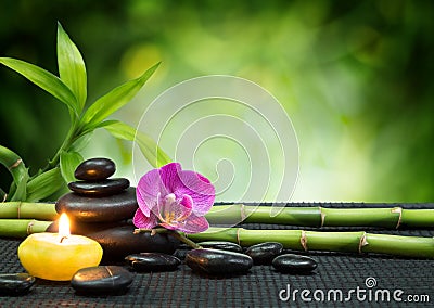 Purple orchid, candle, with stones , bamboo on black mat Stock Photo