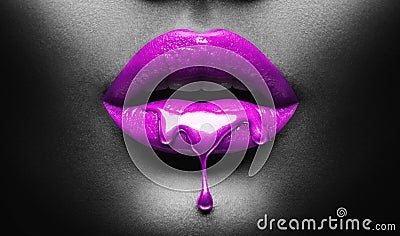 Purple Paint dripping, lipgloss drops on sexy lips, bright liquid paint on beautiful model girl`s mouth, black skin. Lipstick Stock Photo