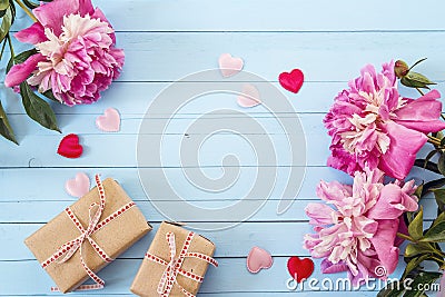 Purple peonies and gift boxes on blue painted wooden planks. Place for text. Stock Photo