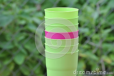 Purple plastic cup between green ones Stock Photo