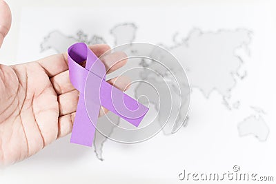 Purple ribbon on a person's hand - awareness of violence against women concept Stock Photo