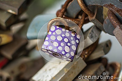 Purple rusty padlock with white dots. Stock Photo