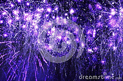 Purple sparkling fireworks exploding in black night sky Stock Photo