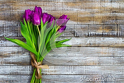 Purple tulip, liliaceae on rustic desk. Cut flower bouquet on wood background Stock Photo