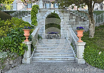 Purple wild pansies in a terracotta planters flanking steps in the Garden of the Villa Cipressi in Varenna. Stock Photo